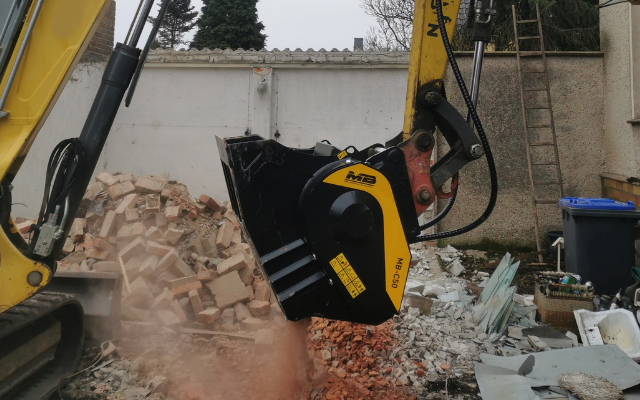 Backenbrecherlöffel MB Crusher MB-C50 installiert auf einen Wacker Neuson Z75 beim Brechen von Bauschutt