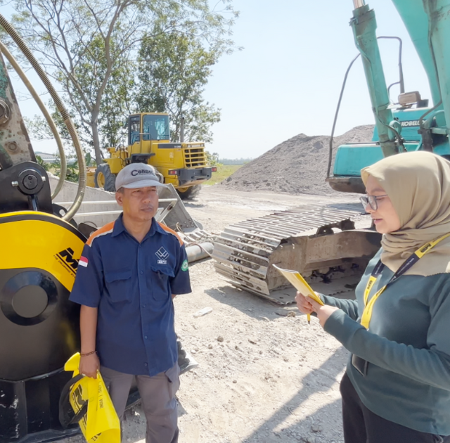 Daur ulang bongkahan rigid beton dengan MB Bucket Crusher untuk rekonstruksi jalan raya.