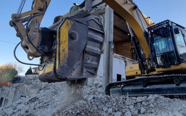 Il frantoio MB Crusher BF120.4 in azione su un cantiere di demolizione, separando il calcestruzzo dal ferro.