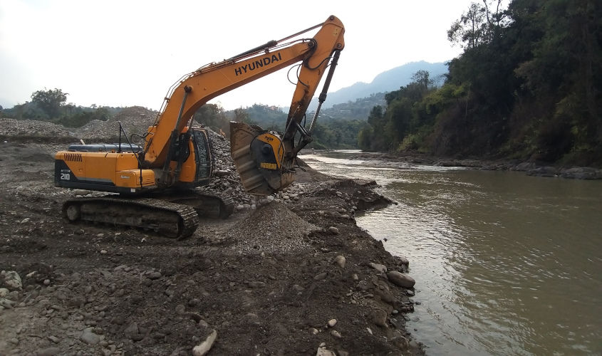 A BF90.3 crusher bucket installed on a Hyundai 215LC excavator, is crushing river stone to produce aggregate for road work. A BF90.3 crusher bucket installed on a Hyundai 215LC excavator, is crushing river stone to produce aggregate for road work.