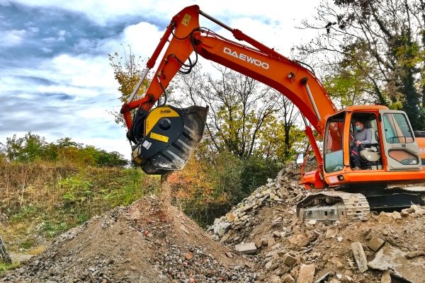 Щековая дробилка MB Crusher, установленная на экскаваторе, измельчает материал, полученный в результате сноса, непосредственно на стройплощадке