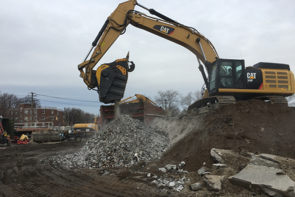 The BF135.8 crusher bucket crushing asphalt before reusing it as a sub-base to repave a parking lot.