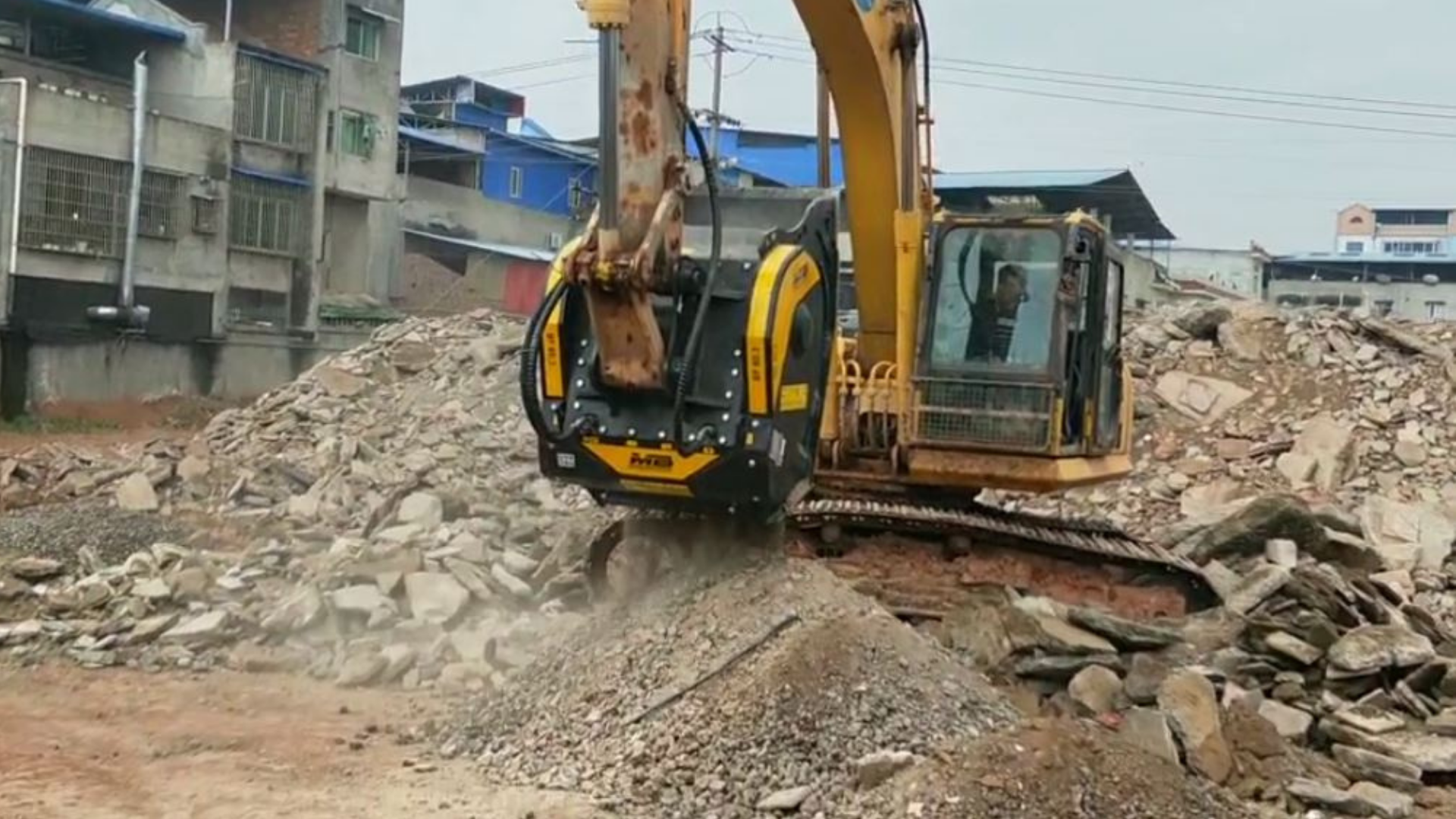 A BF80.3 crusher bucket processing concrete from roads, creating aggregates that will be reused as sub-base for the new road. 